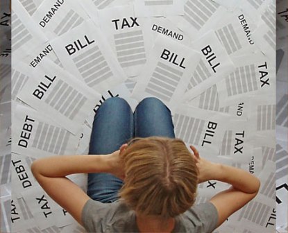 A person surrounded by bills and debt